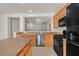 Open kitchen boasts wood cabinets, stainless steel dishwasher, and granite countertops for modern convenience at 33 Gentilly Lace Ave, Henderson, NV 89002