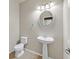 Charming powder room featuring a pedestal sink, toilet, and decorative lighting at 33 Gentilly Lace Ave, Henderson, NV 89002