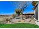 Cozy backyard sitting area with stone pavers, gravel, and mature trees, offering a peaceful outdoor retreat at 33 Hassayampa Trl, Henderson, NV 89052
