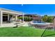 Outdoor living at its finest: lush lawn and spa with covered patio and grill at 33 Hassayampa Trl, Henderson, NV 89052