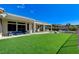 Expansive backyard featuring lush green turf, covered patio, outdoor kitchen, fire pit, and relaxing in-ground spa at 33 Hassayampa Trl, Henderson, NV 89052