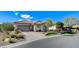 Inviting single-story home with a three-car garage, xeriscaping, and green lawn at 33 Hassayampa Trl, Henderson, NV 89052