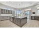 Kitchen featuring stainless appliances, island with counter seating, and bright natural light through oversized windows at 33 Hassayampa Trl, Henderson, NV 89052