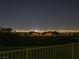 An expansive night view captures the city lights over the hillside and trees at 33 Hassayampa Trl, Henderson, NV 89052