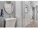 Modern powder room featuring geometric tile, a round mirror, and stylish fixtures at 33 Hassayampa Trl, Henderson, NV 89052