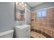 Updated bathroom featuring a walk-in shower with brown tile, new vanity and neutral paint at 352 Cox Ave, Overton, NV 89040
