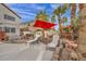 Backyard with outdoor kitchen, red umbrella, lounge chairs and manicured landscaping at 3728 Russell Peterson Ct, Las Vegas, NV 89129