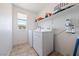 Functional laundry room with washer, dryer, shelving, and natural light at 3981 E Teller Dr, Pahrump, NV 89061