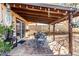 Covered backyard patio with a dining area, string lights, and well-maintained landscaping at 432 Bottle Brush Way, Henderson, NV 89015