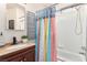 Bathroom features a vanity with wood cabinets and a shower/tub combo with a bright, patterned curtain at 432 Bottle Brush Way, Henderson, NV 89015