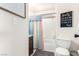 Bathroom with a toilet and a shower tub with colorful curtain and motivational Gathering quotes at 432 Bottle Brush Way, Henderson, NV 89015