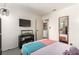 Well lit bedroom with tv, reptile terrarium, mirror, and adjacent laundry room at 432 Bottle Brush Way, Henderson, NV 89015