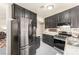 Galley kitchen with stainless appliances and granite counters open to living room at 432 Bottle Brush Way, Henderson, NV 89015
