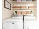 Functional laundry area with neatly arranged baskets, cleaning supplies, washer and dryer at 432 Bottle Brush Way, Henderson, NV 89015
