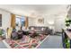 Relaxing living room features an L-shaped sofa, a colorful rug, and stylish decor at 432 Bottle Brush Way, Henderson, NV 89015