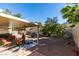 Spacious backyard featuring a covered patio, mature landscaping, and gravel ground cover at 455 Paulson Dr, Las Vegas, NV 89123