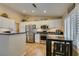 Bright kitchen with stainless steel appliances, white cabinets, and a breakfast bar at 455 Paulson Dr, Las Vegas, NV 89123