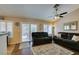 Comfortable living room with dark sofas, ceiling fan, and sliding glass doors to the backyard at 455 Paulson Dr, Las Vegas, NV 89123