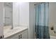 Bright bathroom featuring a vanity with white cabinets and a shower/tub with a blue patterned shower curtain at 4850 Straight Flush Dr # 103, Las Vegas, NV 89122