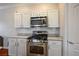 Modern kitchen with stainless steel range and microwave, white cabinets and subway tile backsplash at 4850 Straight Flush Dr # 103, Las Vegas, NV 89122