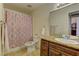 Bathroom showcasing a vanity with granite countertops, toilet, and shower with patterned curtain at 5161 Lindell Rd # 201, Las Vegas, NV 89118