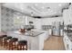 Bright kitchen features an island, granite counters, stainless appliances, and decorative black and white backsplash and accent wall at 563 Moon Chase St, Las Vegas, NV 89110
