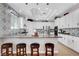 Well-lit kitchen boasts granite counters, an island, and black and white patterned backsplash and accent wall at 563 Moon Chase St, Las Vegas, NV 89110