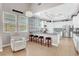 Well-lit kitchen featuring breakfast bar, white cabinets, modern appliances, and backyard views at 563 Moon Chase St, Las Vegas, NV 89110