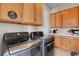 Functional laundry room with built-in cabinets, countertop, and modern gray washer and dryer at 563 Moon Chase St, Las Vegas, NV 89110