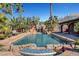 Inviting backyard pool with rock waterfall, mature landscaping and a built-in table with seating at 563 Moon Chase St, Las Vegas, NV 89110
