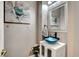 Stylish powder room with a unique vessel sink, decorative mirror, and accent artwork at 563 Moon Chase St, Las Vegas, NV 89110