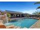 Gorgeous custom pool with rock waterfall feature and covered patio with outdoor seating area at 563 Moon Chase St, Las Vegas, NV 89110
