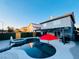 Backyard pool with red umbrella, hot tub, and barbecue area provide a great outdoor living and entertaining space at 5705 Enchanted Palms Ave, Las Vegas, NV 89139