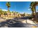 Well-maintained community entrance with palm trees, manicured landscaping, and decorative stone signage at 6255 W Arby Ave # 183, Las Vegas, NV 89118