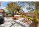 Landscaped backyard featuring a hot tub, mature trees, and a patio area at 653 Freeburg Pl, Las Vegas, NV 89123