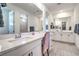 Bathroom vanity with white cabinets, quartz countertop, large mirror reflecting a shower and walk-in closet at 6593 Corsari Ridge St, Las Vegas, NV 89166