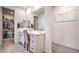 Bathroom vanity showcases white cabinets, a quartz countertop, a large mirror, and access to a walk-in closet at 6593 Corsari Ridge St, Las Vegas, NV 89166