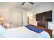 Bedroom with a large television, wood dresser, and adjacent bathroom at 6593 Corsari Ridge St, Las Vegas, NV 89166