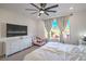 Bedroom with a ceiling fan, large window and view of backyard play structure at 6593 Corsari Ridge St, Las Vegas, NV 89166