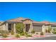 Attractive single-story home featuring stone accents, tile roof, paver driveway, and mature landscaping at 6593 Corsari Ridge St, Las Vegas, NV 89166