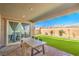 Covered patio has an outdoor dining area with mountain views, green turf, and easy access to the house at 6593 Corsari Ridge St, Las Vegas, NV 89166