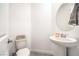 Neat powder room with pedestal sink, round mirror, and neutral tones at 6593 Corsari Ridge St, Las Vegas, NV 89166