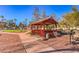 A cozy red gazebo is surrounded by a landscaped area with walkways, trees, and lush greenery at 725 N Royal Crest Cir # 227, Las Vegas, NV 89169