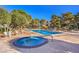 A tranquil in-ground hot tub and pristine pool are nestled amongst lush landscaping under a bright blue sky at 725 N Royal Crest Cir # 227, Las Vegas, NV 89169