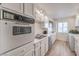 Well-lit kitchen featuring white cabinetry, stainless steel sink, and modern appliances at 725 N Royal Crest Cir # 227, Las Vegas, NV 89169