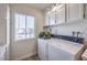 Laundry area with washer/dryer and white cabinets, located near a bright window at 725 N Royal Crest Cir # 227, Las Vegas, NV 89169