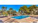 A pristine pool is surrounded by lounge chairs and manicured greenery, under a clear, sunny sky at 725 N Royal Crest Cir # 227, Las Vegas, NV 89169