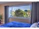 Main bedroom window showcasing a picturesque view of lush greenery and cityscape at 725 N Royal Crest Cir # 227, Las Vegas, NV 89169