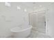 Bright bathroom featuring a soaking tub, a glass shower and small accent windows at 7255 Bold Rock Ave, Las Vegas, NV 89113