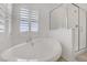 Close up of a soaking tub next to a glass shower in a bright, modern bathroom at 7255 Bold Rock Ave, Las Vegas, NV 89113